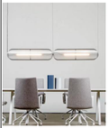 Avlang opalglass pendellampe med gullramme over spisebord