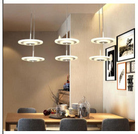 Rund LED pendellampe med flere lyshoder i krom over spisebord