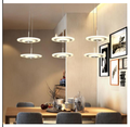 Rund LED pendellampe med flere lyshoder i krom over spisebord