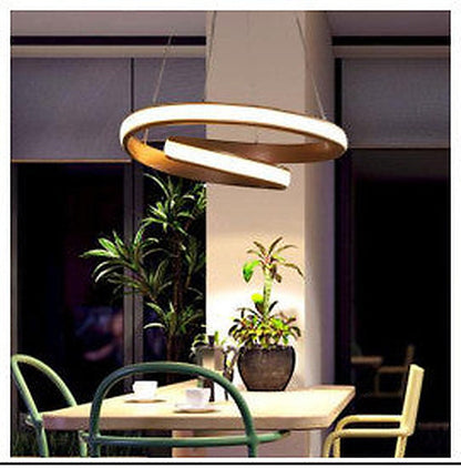 Spiralformet gull LED pendellampe over spisebord