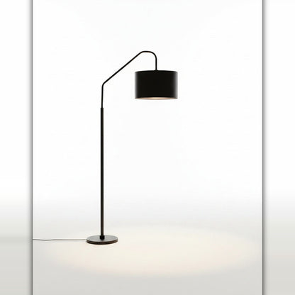 Lysverden sort buegulvlampe med sylindrisk stoffskjerm som gir mykt stemningslys i stuen.