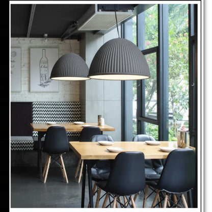 Lysverden grey ribbed dome pendant lights hanging over wooden dining tables in a modern restaurant interior