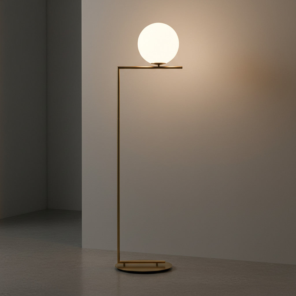 Lysverden gullfarget gulvlampe med lysende kuleskjerm i opalglass og minimalistisk metallramme i moderne interiør.