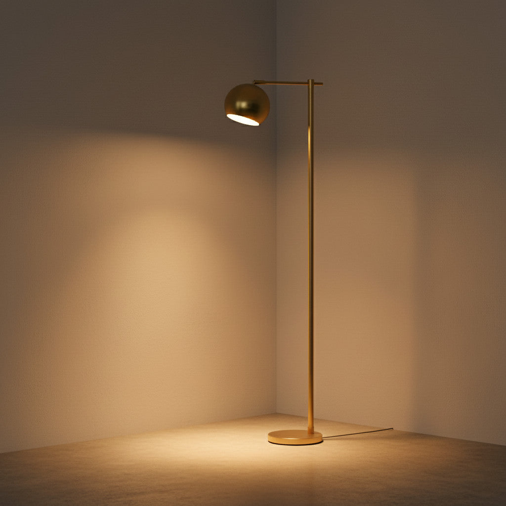 Lysverden minimalistisk gullfarget gulvlampe med slank stamme, rund fot og justerbart, vippbart hode i et hjørne.