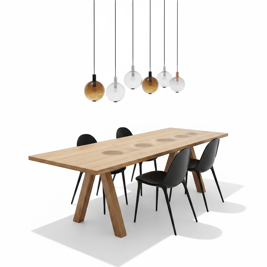 Lysverden AMBER pendant lights with gradient glass shades hanging over a wooden dining table with black chairs.
