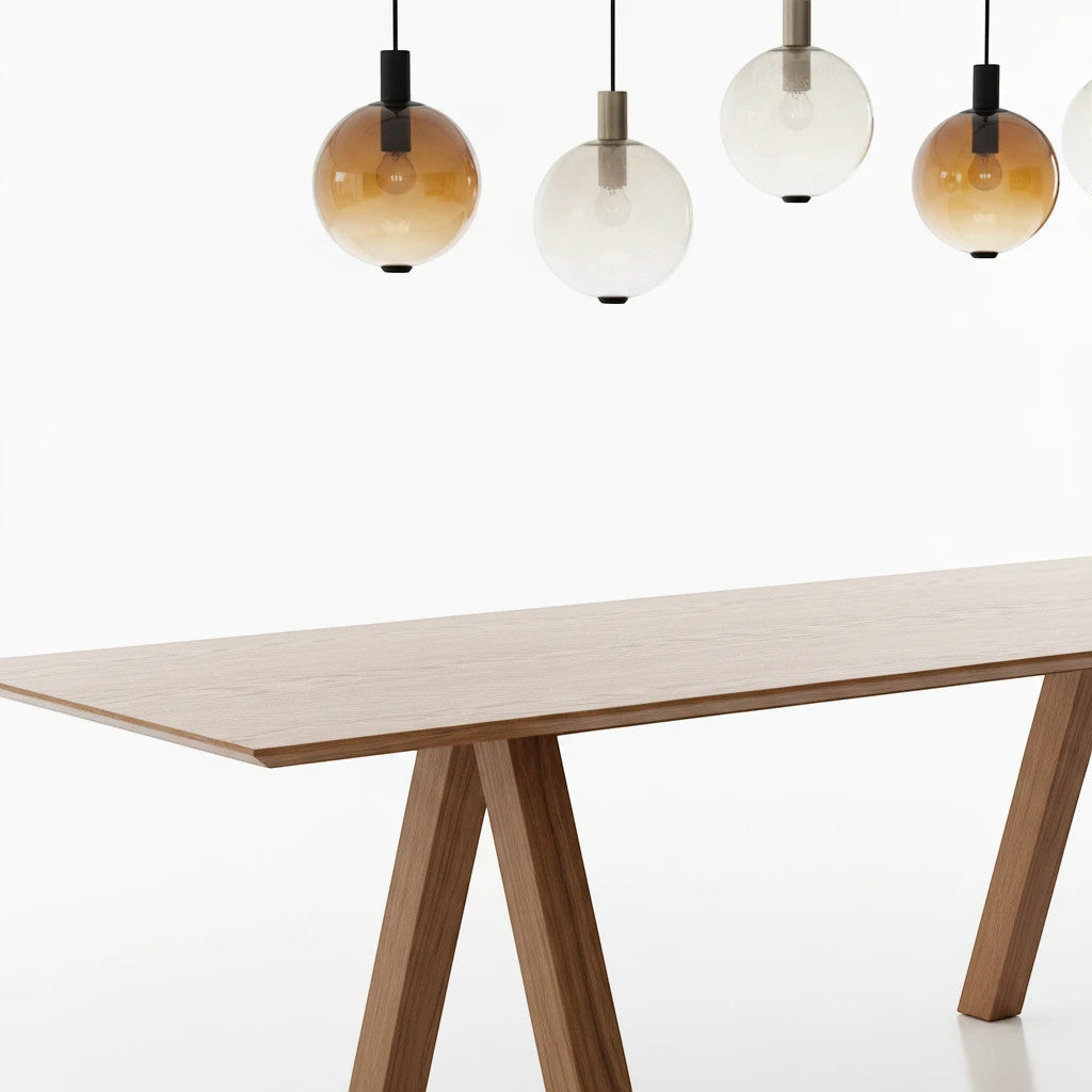 Lysverden AMBER pendant lights with gradient tinted glass shades hanging in a row above a wooden dining table.
