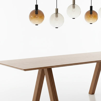 Lysverden AMBER pendant lights with gradient tinted glass shades hanging in a row above a wooden dining table.