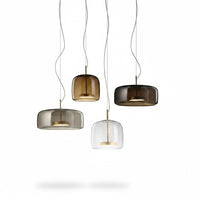 Lysverden bell-shaped pendant lights in smoke, amber, and clear glass with metallic accents hanging in a cluster