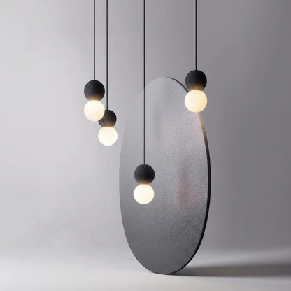 Lysverden Betongpendel minimalist pendant lights with matte concrete tops and glowing glass spheres in a cluster