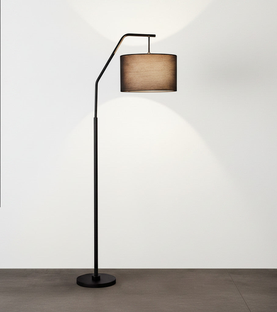 Lysverden black arched floor lamp with a fabric drum shade providing warm, diffused lighting for a living room.