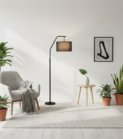 Lysverden black arched floor lamp with a fabric shade in a modern living room with a grey armchair and indoor plants