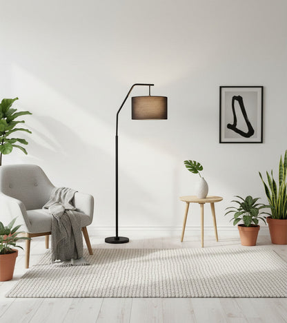 Lysverden black arched floor lamp with a fabric shade in a modern living room with a grey armchair and indoor plants