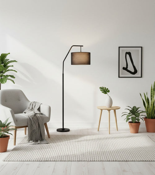 Lysverden black arched floor lamp with a fabric shade in a modern living room with a grey armchair and indoor plants