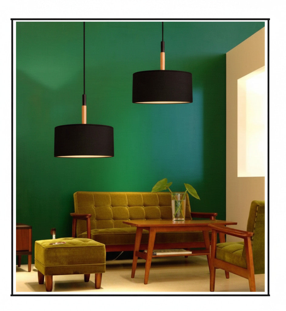 Lysverden black drum pendant lights with natural wood top details hanging in a modern living room with green walls.