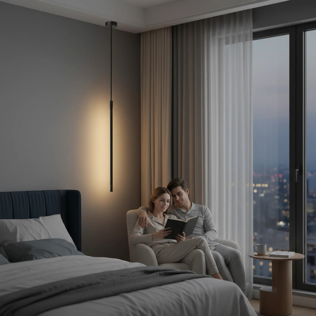 Lysverden minimalist black linear LED pendant light hanging in a modern bedroom with a couple reading in an armchair.