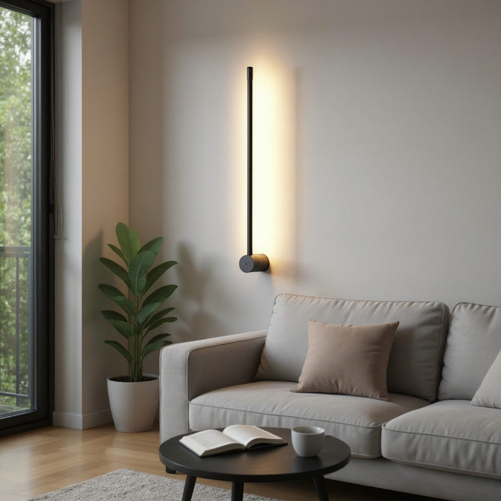 Lysverden modern black linear LED wall lamp casting a warm glow on a living room wall above a sofa