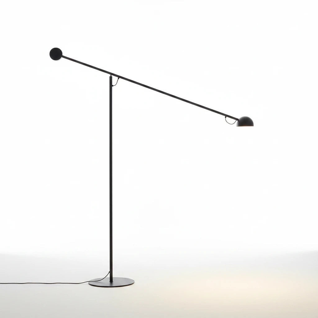 Lysverden minimalistisk gulvlampe i sort metall med lang utliggerarm for fokusert lys i moderne interiør.