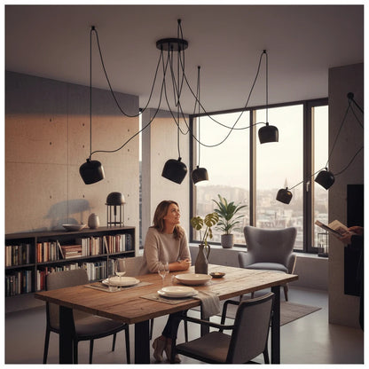 Lysverden industrial black metal drum pendant cluster light hanging over a wooden dining table in a modern living room