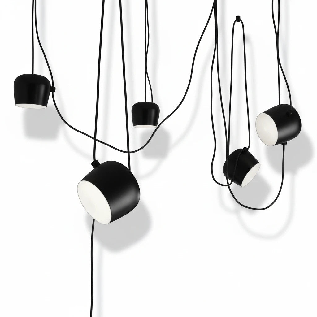 Lysverden industrial black metal drum pendant lights with adjustable heads and white diffusers hanging in a cluster.