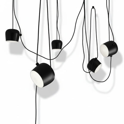 Lysverden industrial black metal drum pendant lights with adjustable heads and white diffusers hanging in a cluster.