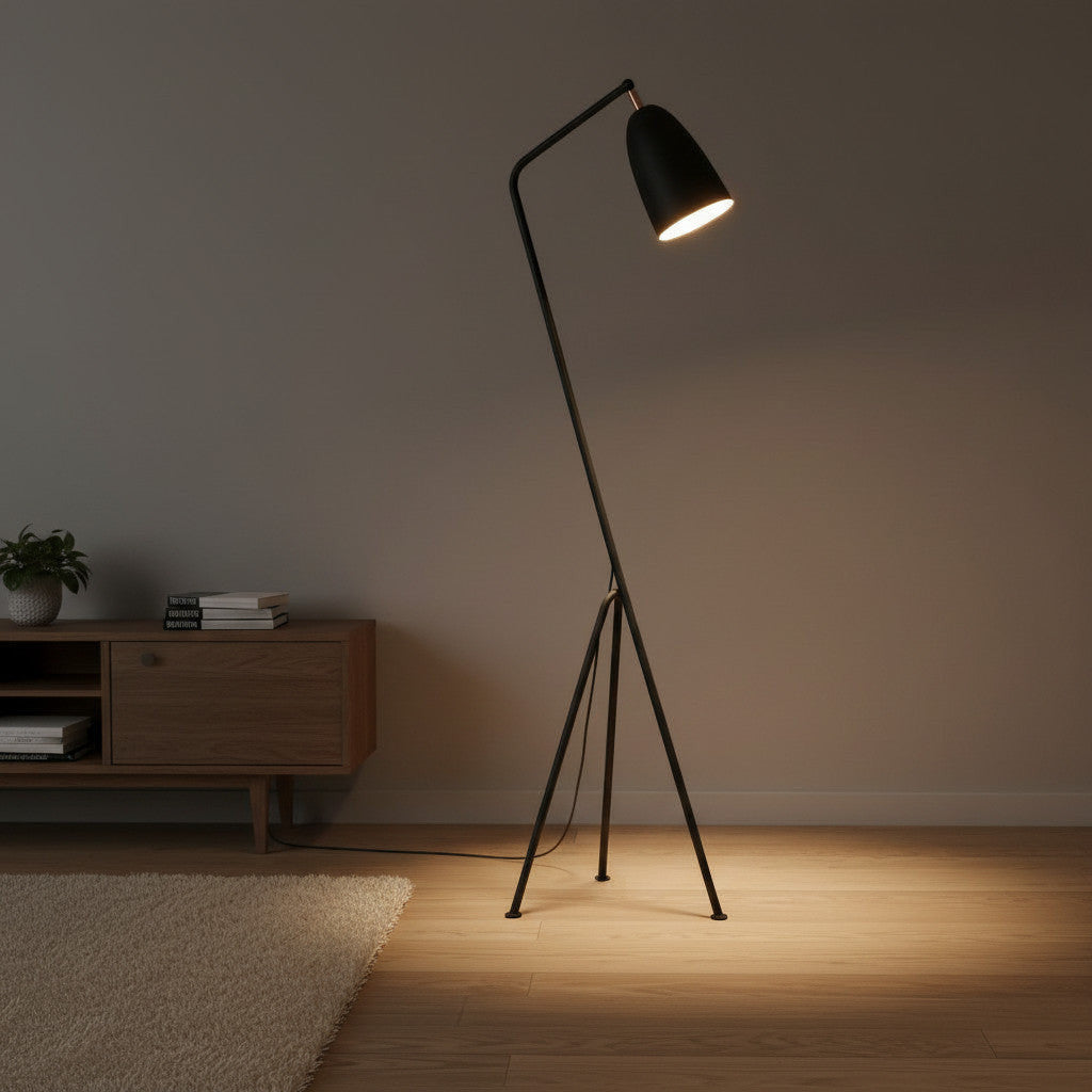 Lysverden black metal tripod floor lamp with an adjustable cone shade in a modern Scandinavian living room interior.
