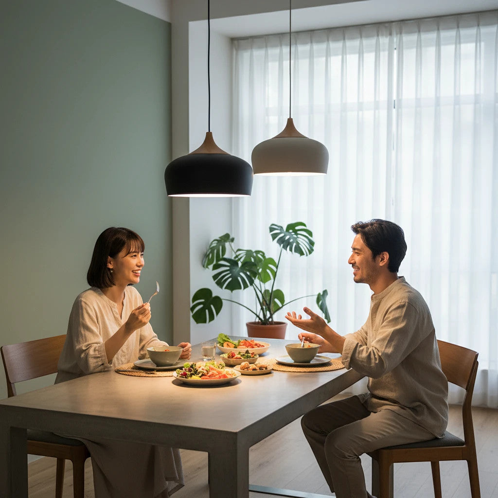 Lysverden black and white dome pendant lights with wood accents hanging over a couple dining at a modern table