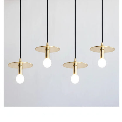 Lysverden moderne messingskivependler med synlige pærer, hengende på rad for minimalistisk spisestuebelysning.