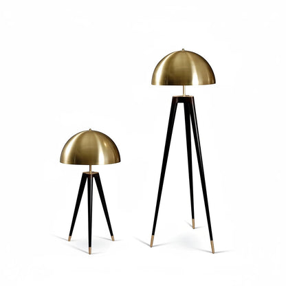 Lysverden tripod lamps with brass dome shades and black three-legged bases in table and floor lamp sizes.