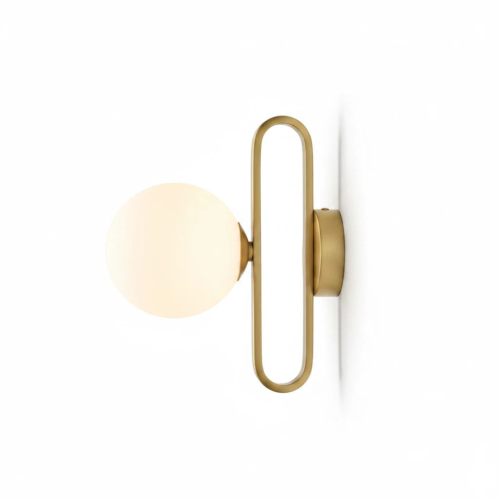 Lysverden Nordic wall lamp with a brass frame and spherical frosted glass shade emitting a warm glow.