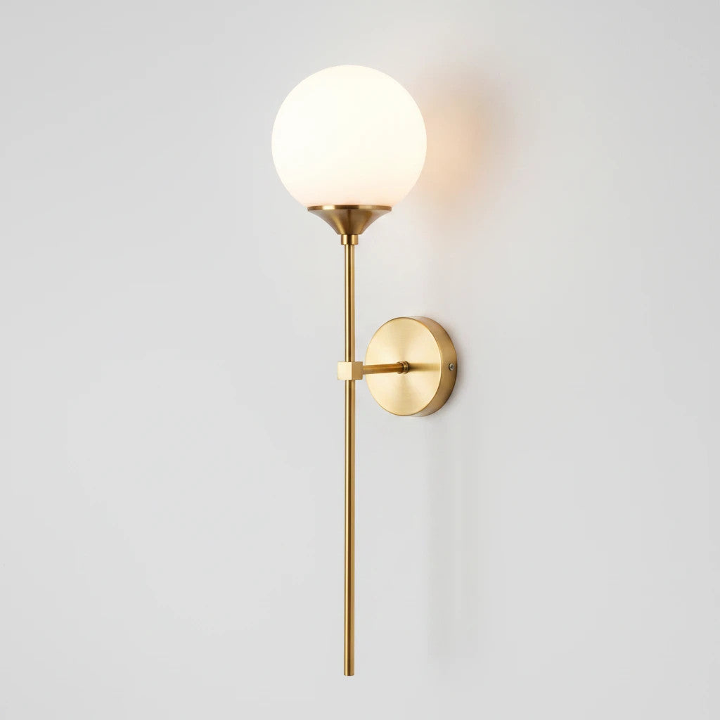 Lysverden elegant wall lamp with a slim brass stem and a round opal glass globe shade for soft, diffused lighting.
