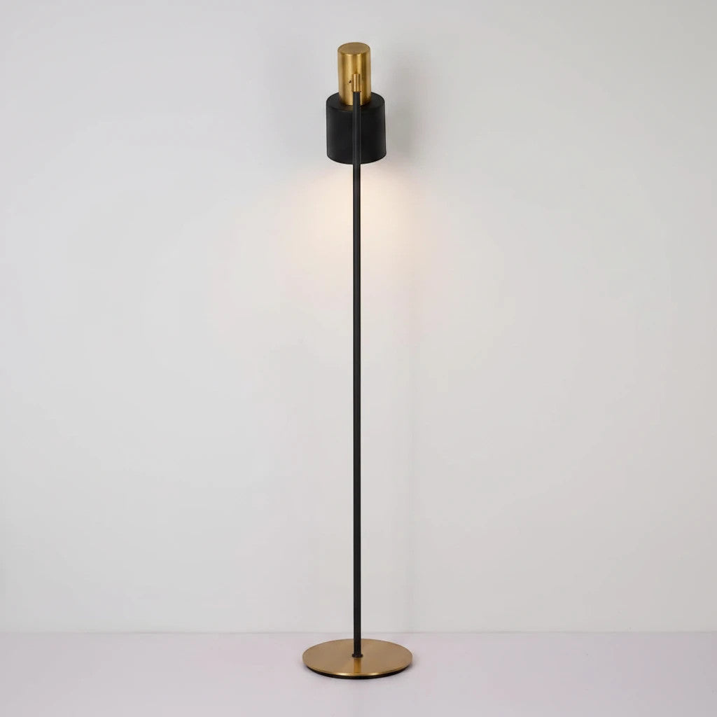 Lysverden classic floor reading lamp with a slim black stem, round brass base, and adjustable black and gold shade.