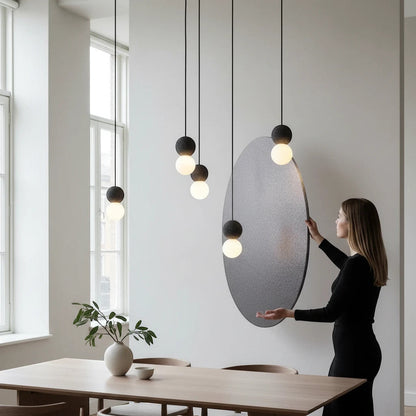 Lysverden minimalist concrete and glass globe pendant lights hanging in a cluster over a modern dining table