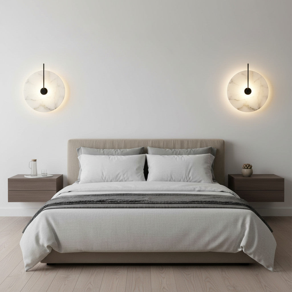 Lysverden Dolomitt minimalist wall lamps with white stone discs and warm LED glow mounted above a modern bed