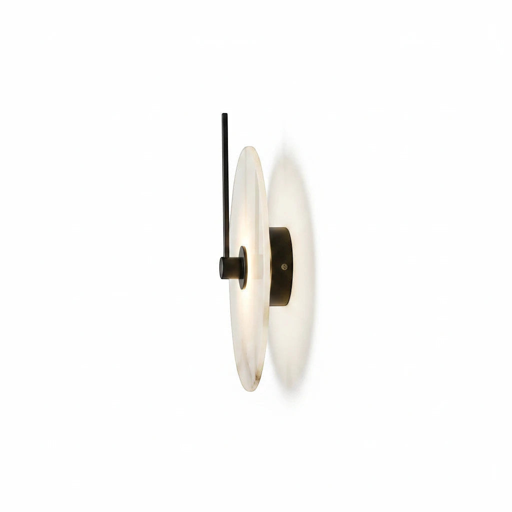 Lysverden Dolomitt wall lamp with a round white stone disc and black metal detail, creating soft indirect LED light.