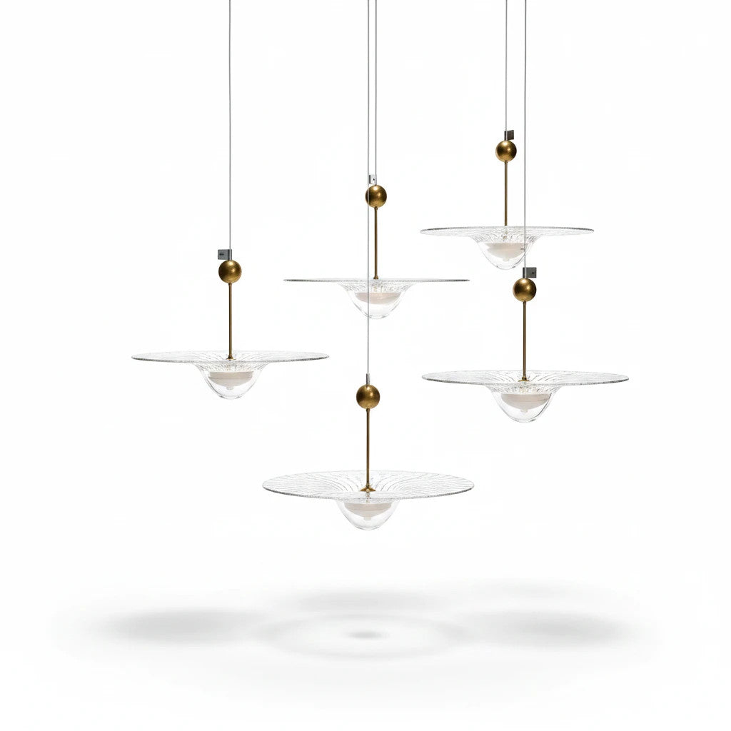 Lysverden modern pendant light cluster with clear glass discs and brass accents, creating a warm ambient glow.