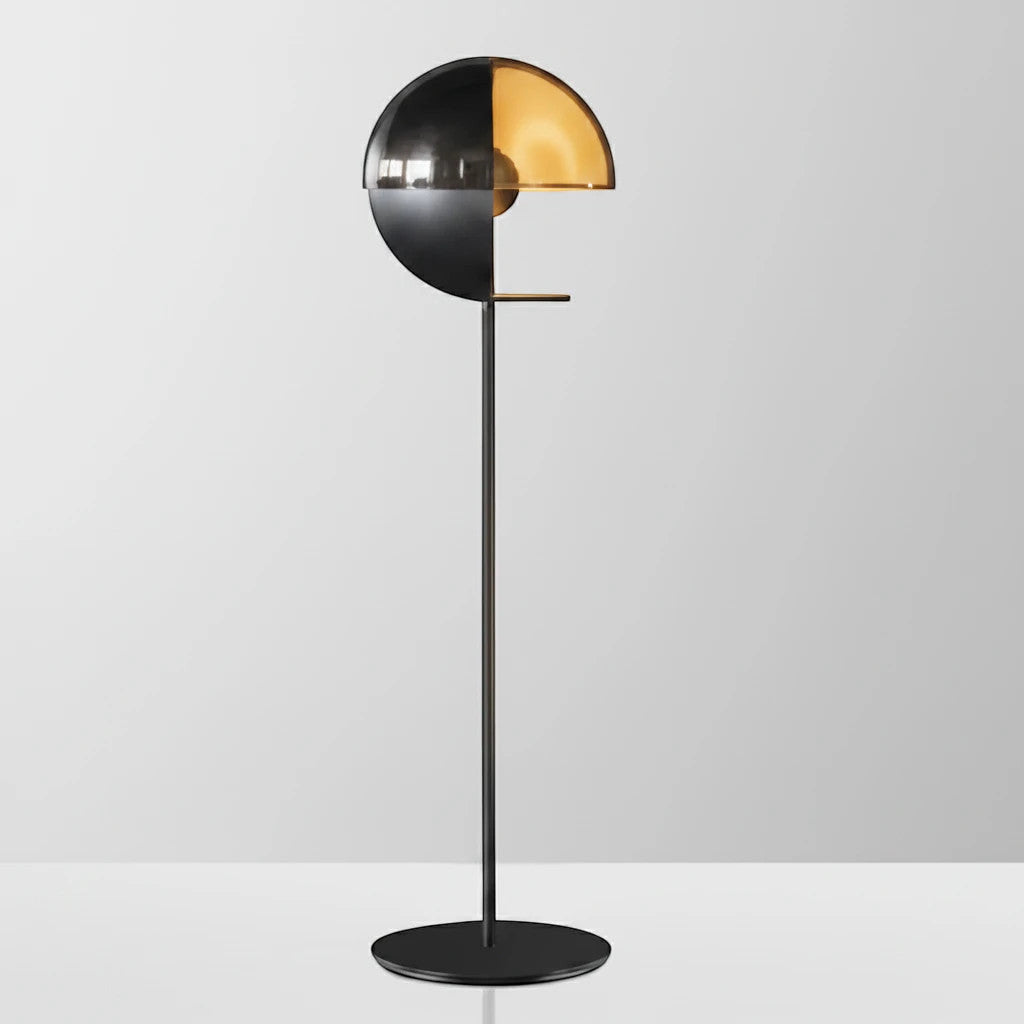 Lysverden gulvlampe med moderne sort stamme og dekorativ halvkuppel i gullfarget glass for varmt stemningslys.