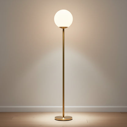 Lysverden minimalist floor lamp with a gold metal stand and a glowing opal glass sphere providing warm ambient light.