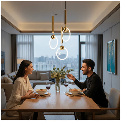 Lysverden gold ring pendant lights hanging above a dining table with a couple enjoying a meal in a modern apartment.