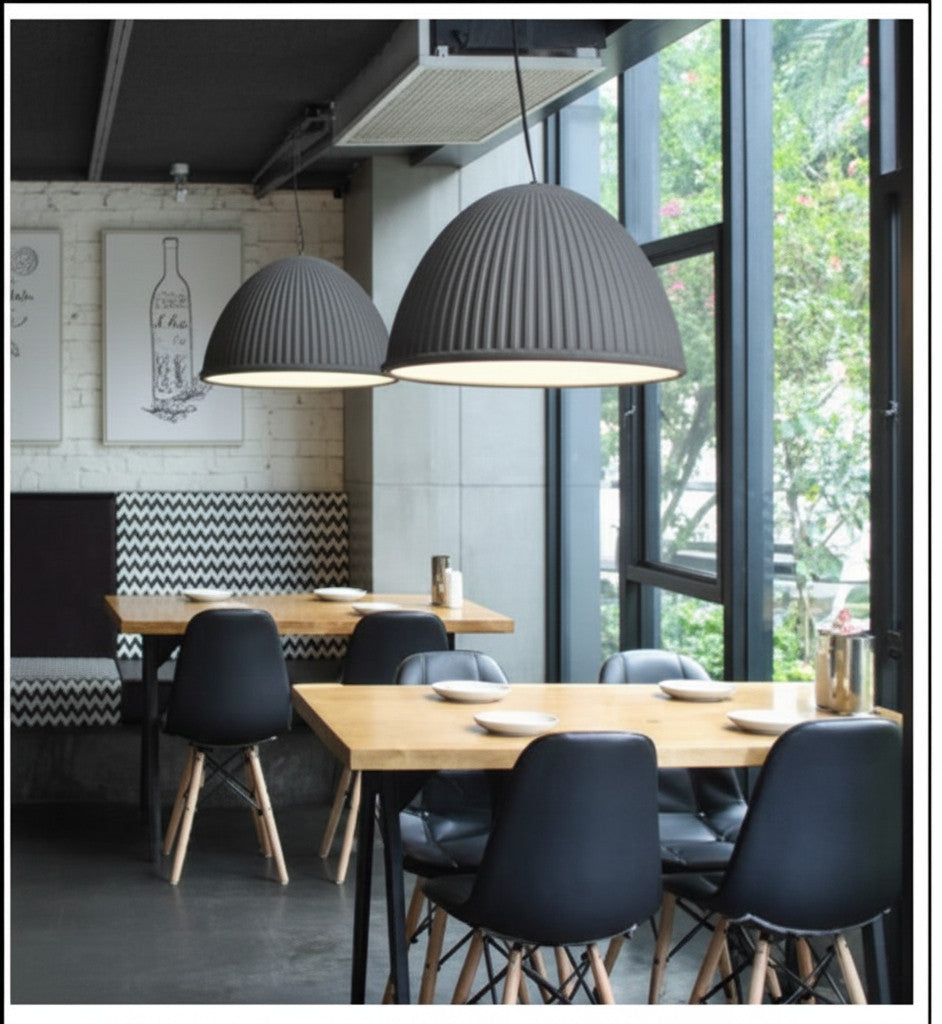 Lysverden grey ribbed dome pendant lights hanging over wooden dining tables in a modern restaurant interior
