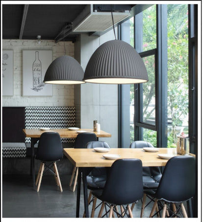 Lysverden grey ribbed dome pendant lights hanging over wooden dining tables in a modern restaurant interior