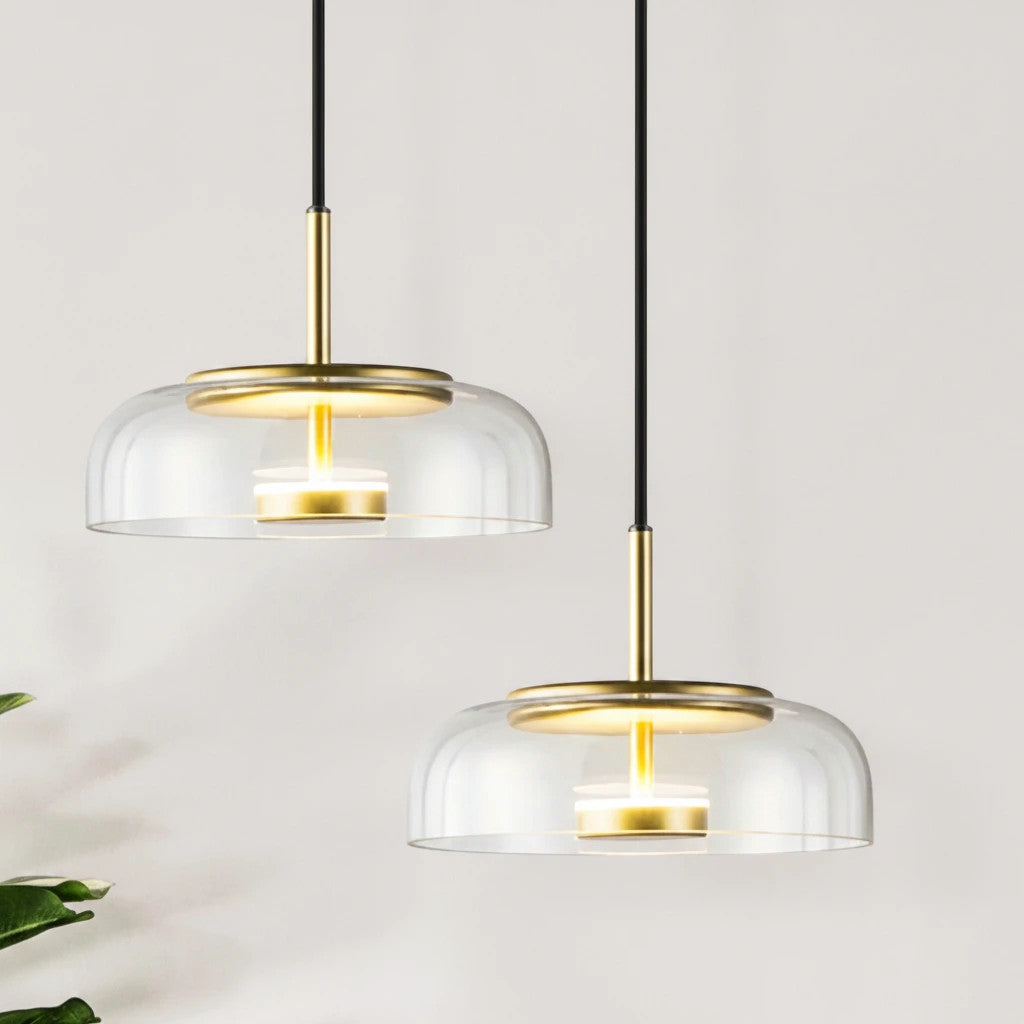 Lysverden KUPPEL pendant lights with clear glass domes and gold brass reflector discs for warm, elegant lighting.