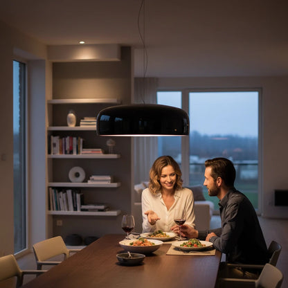 Lysverden Kuppelpendel black glossy metal dome pendant lamp hanging over a dining table with a couple eating dinner.