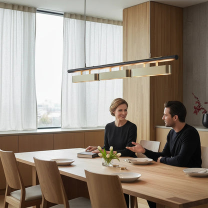 Lysverden linear wood and brushed brass LED pendant light hanging over a modern dining table with a couple sitting