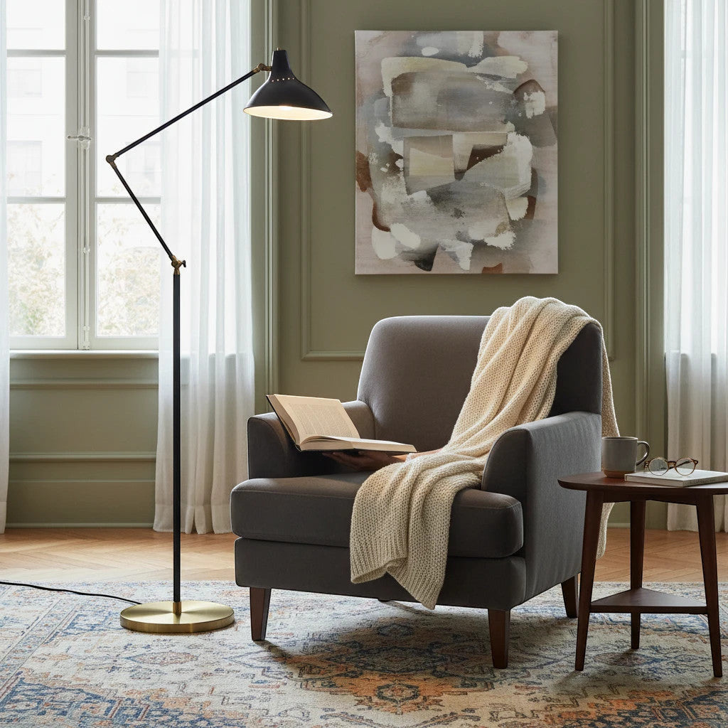 Lysverden LYS floor lamp with matte black finish and brass base, featuring an adjustable shade in a cozy reading nook