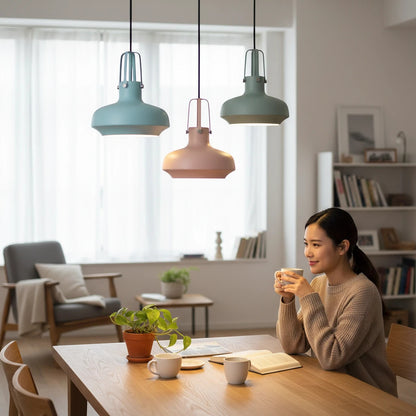 Lysverden Macaron metal pendant lights in pastel blue, pink, and green hanging over a dining table in a bright room.