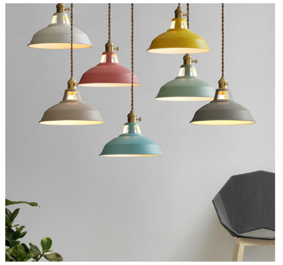 Lysverden Macaron pendant lights in various pastel colors with wooden details, hanging in a group against a wall.