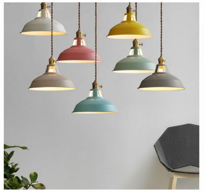 Lysverden Macaron pendant lights in various pastel colors with wooden details, hanging in a group against a wall.