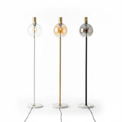 Lysverden floor lamps with marble bases, glass globes, and white, gold, and black metal stems in a minimalist style.