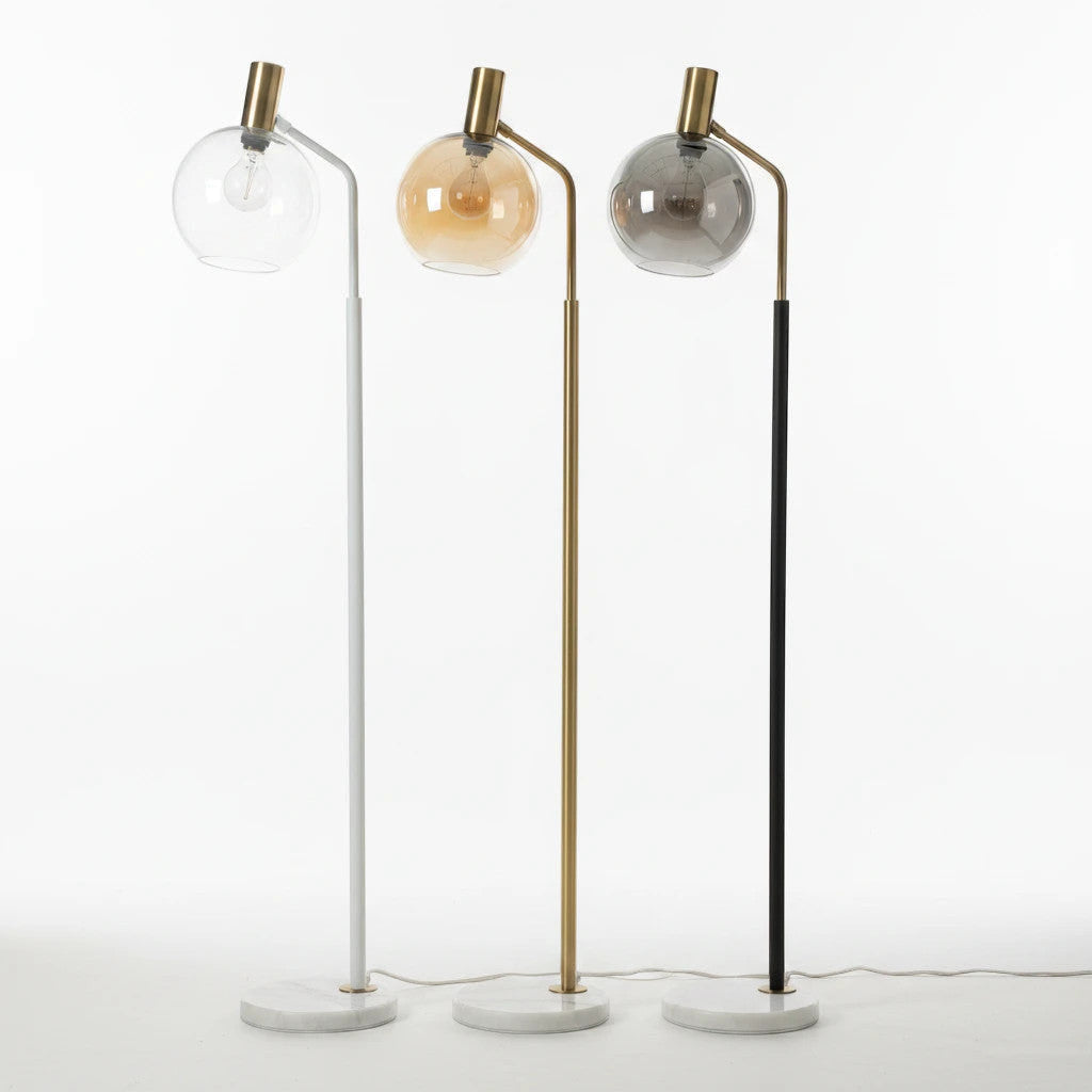 Lysverden floor lamps with marble bases, glass globes, and white, gold, and black metal stems in a minimalist style.