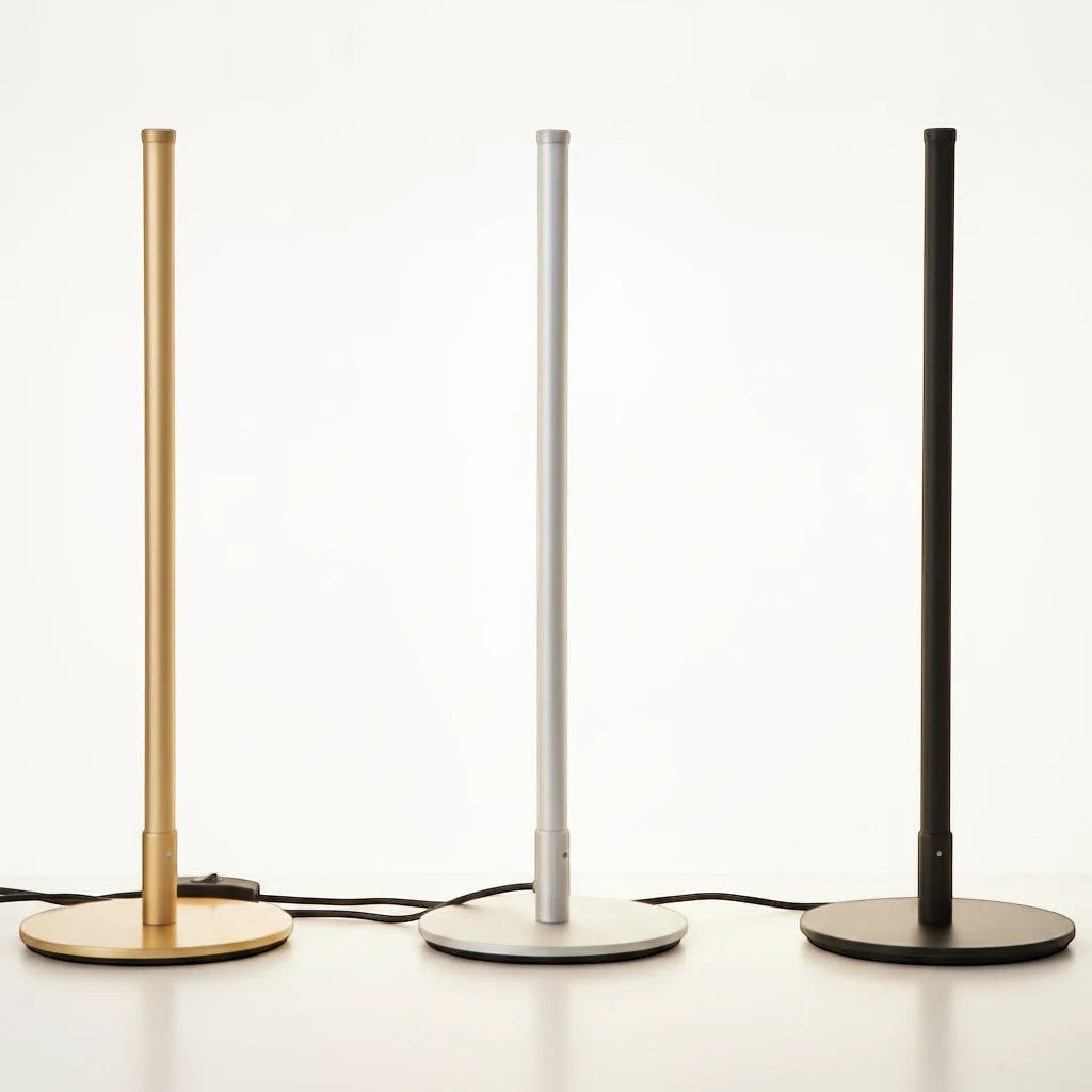 Lysverden minimalist LED floor lamps in gold, silver, and black metal standing in a row on a white surface.